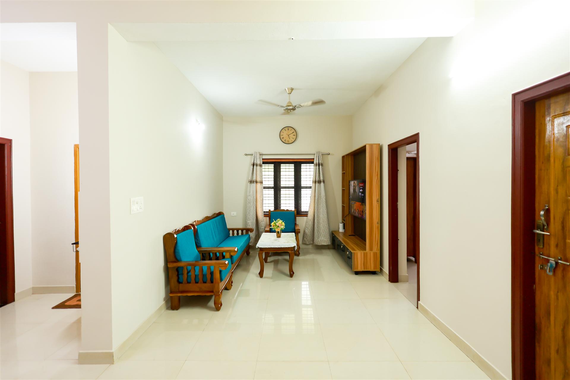 Aranya Ocean Breeze spacious living room with teak wood furniture and turquoise cushions